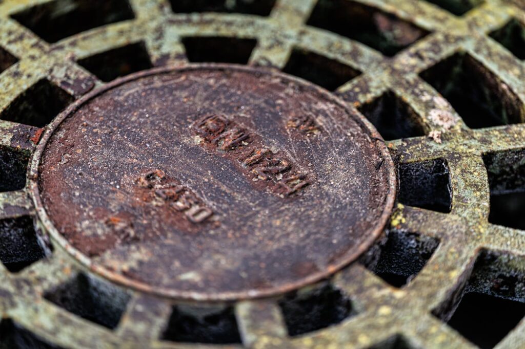 Detailed view of an aged, rusty metal grate showcasing intricate texture and decay.